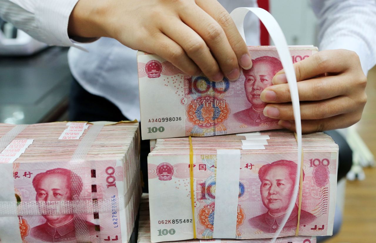 An employee packages 100-yuan notes at a bank in Nantong in China's eastern Jiangsu province on July 23, 2018.