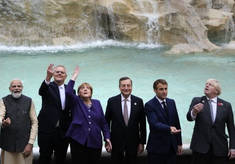 G20 leaders from left, India's Prime Minister Narendra Modi, Australia's Prime Minister Scott Morrison, German Chancellor Angela Merkel, Italy's Prime Minister Mario Draghi, French President Emmanuel Macron and British Prime Minister Boris Johnson perform the traditional coin toss in front of the Trevi Fountain during an event for the G20 summit in Rome, Sunday, October 31, 2021.