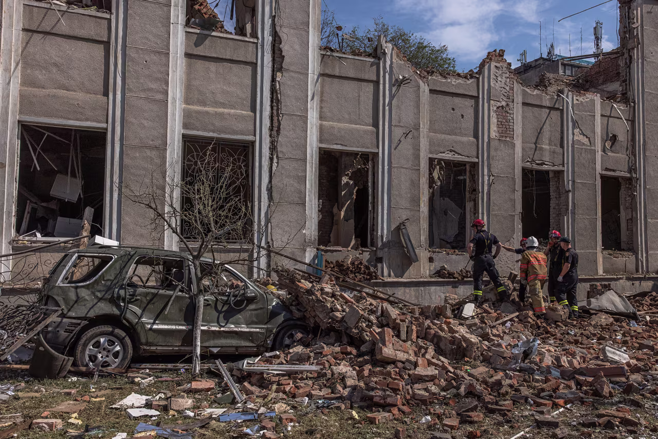 Rescuers work next to a damaged building the day after a Russian missile strike in Vinnytsia, Ukraine, on 15 July.
