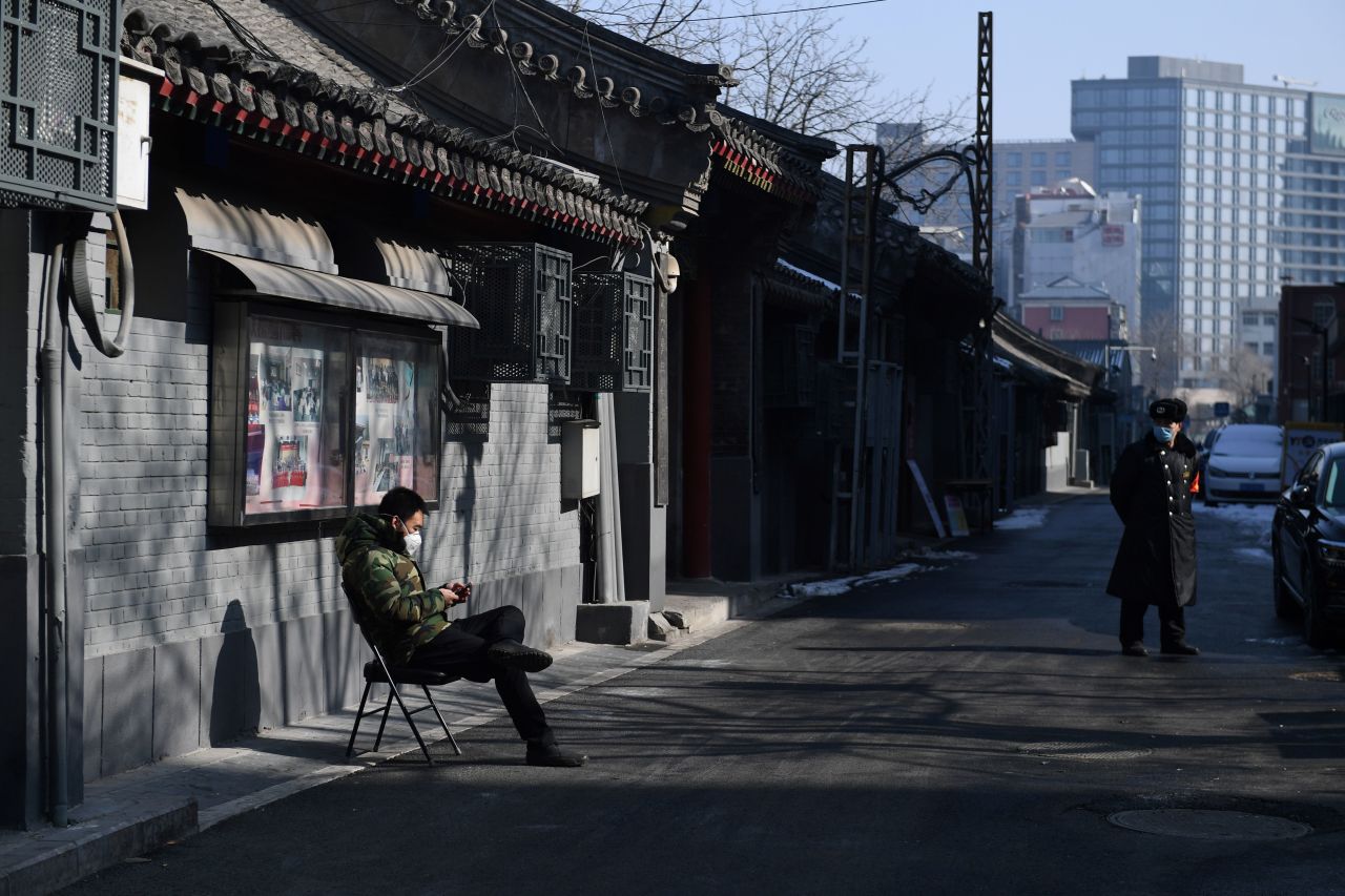 A man monitors traffic in an alley in central Beijing on February 10, 2020.