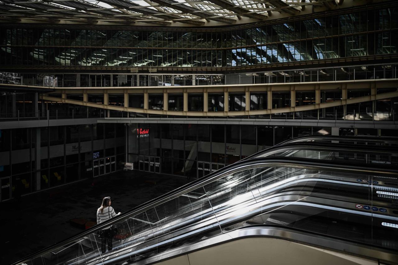 A person is seen on an escalator on March 19 at the Halles shopping mall in Paris, where shops are closed.