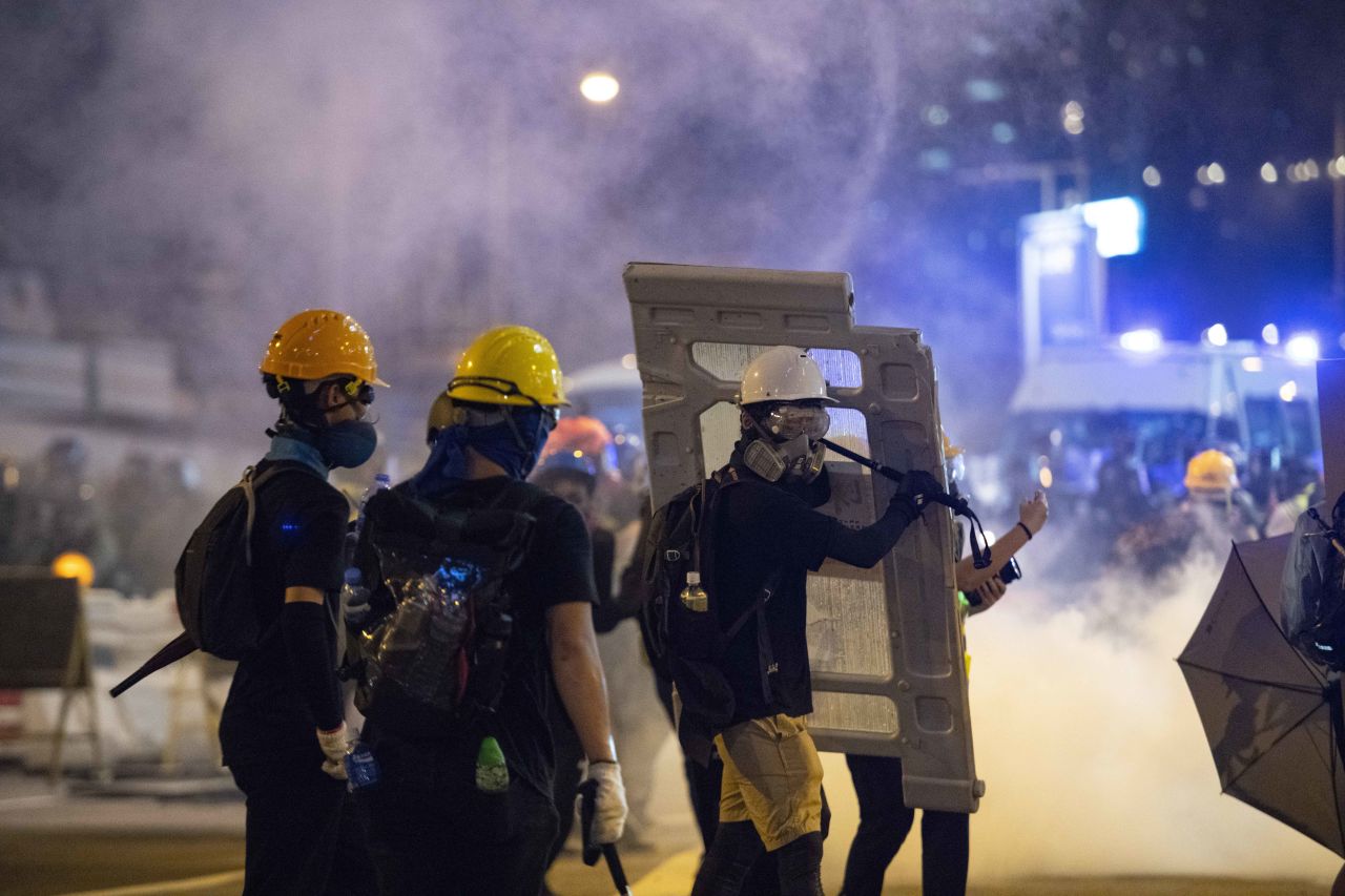 Protesters take cover amid a barrage of tear gas fire. 