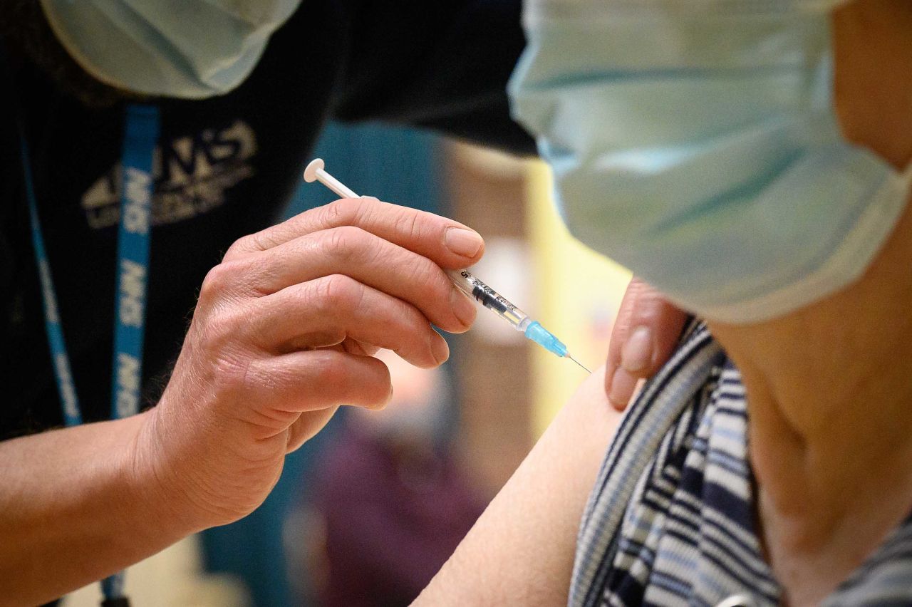 Olive Talender receives an injection at a COVID-19 vaccination center in Chertsey, England on December 16.