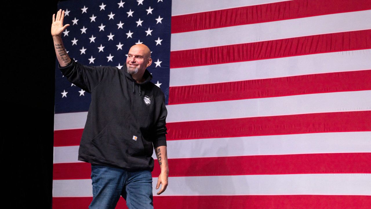 John Fetterman waves as he arrives on stage at his election night watch party in Pittsburgh.