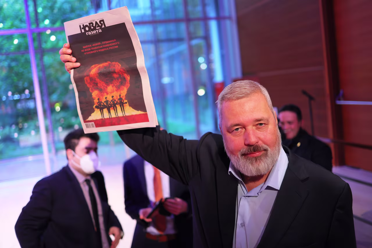 Nobel Peace Prize winner Dmitry Muratov, editor-in-chief of the Russian newspaper Novaya Gazeta, holds up a copy of his paper after the conclusion of bidding during a charity auction in New York on June 20, 2022.