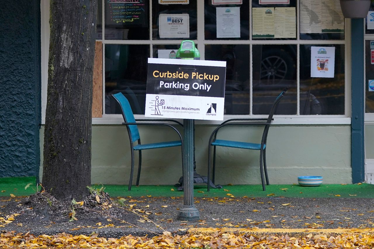 A sign for curbside pickup is shown outside the Cascadia Grill, in downtown Olympia, Washington, on November 15.