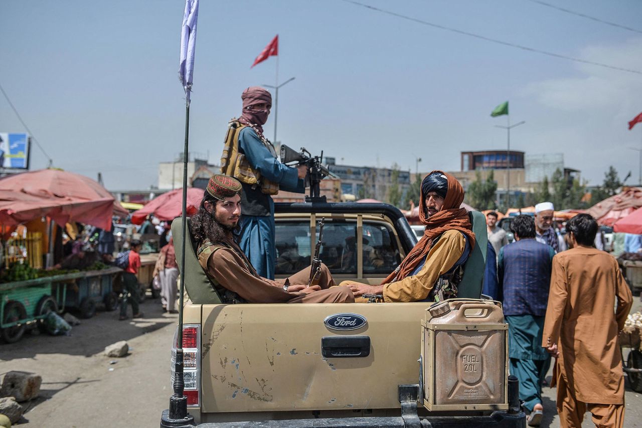 Taliban fighters drive around a market in Kabul on August 17.