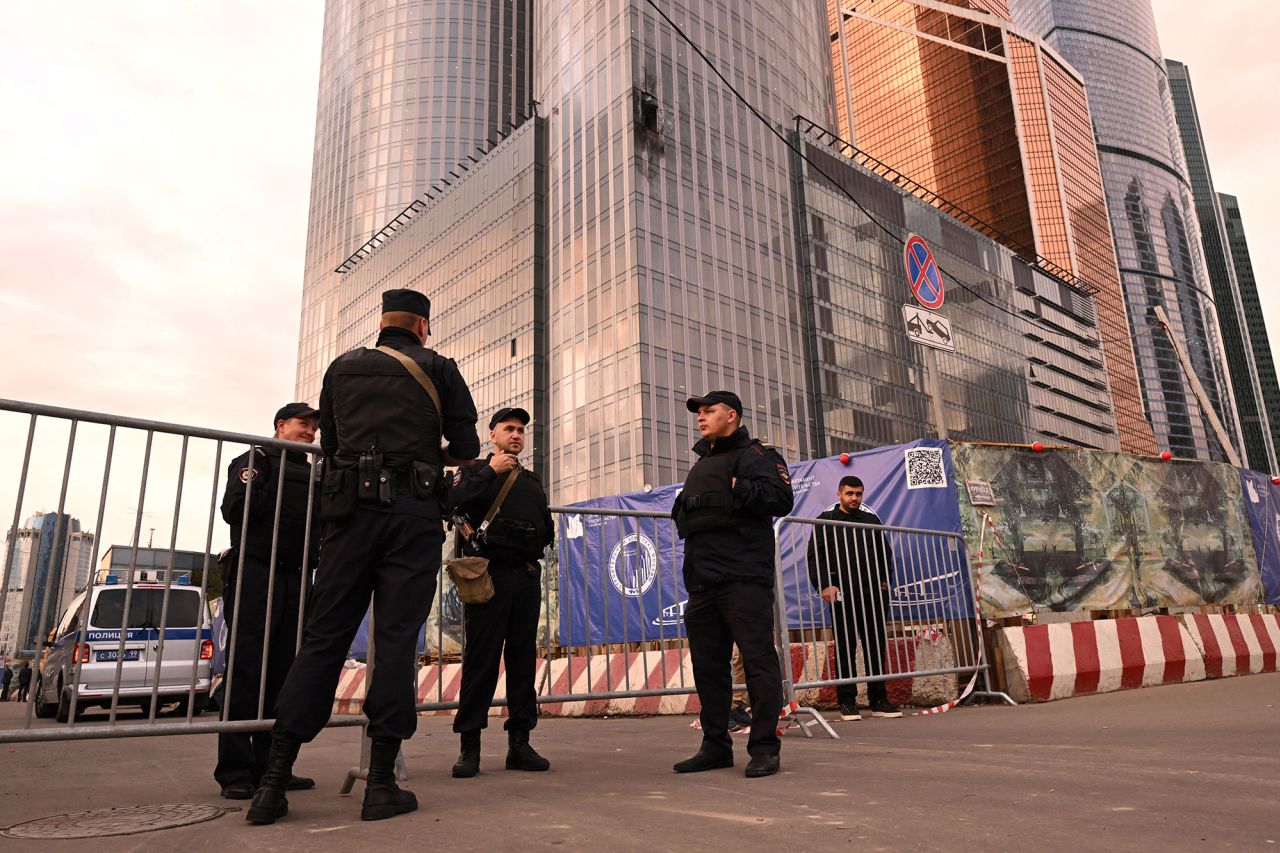 Law enforcement officers stand next to a damaged building of the Moscow International Business Center following a drone attack in Moscow, Russia, on August 23.