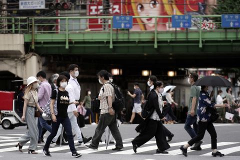 Pedestrians wear protective face masks to help curb the spread of the coronavirus while walking on Friday, July 10, in Tokyo. 