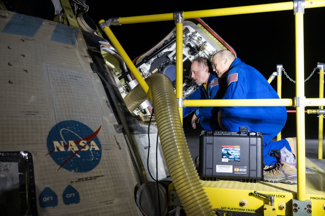 NASA astronauts Mike Fincke, left, and Scott Tingle look inside NASA's Boeing Crew Flight Test Starliner spacecraft after it landed uncrewed at White Sands Missile Range’s Space Harbor, in New Mexico, on September 7.