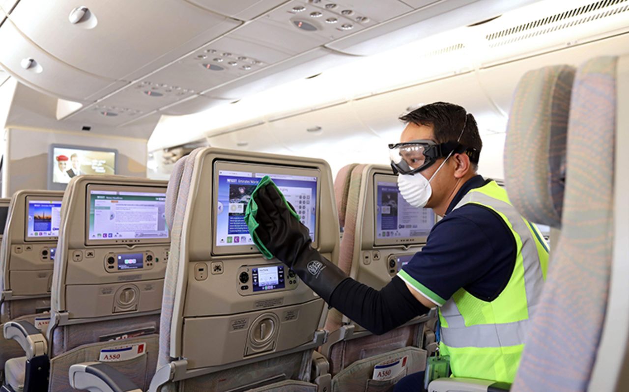 A member of the cleaning staff disinfects screens aboard an Emirates Airbus A380-800 aircraft.