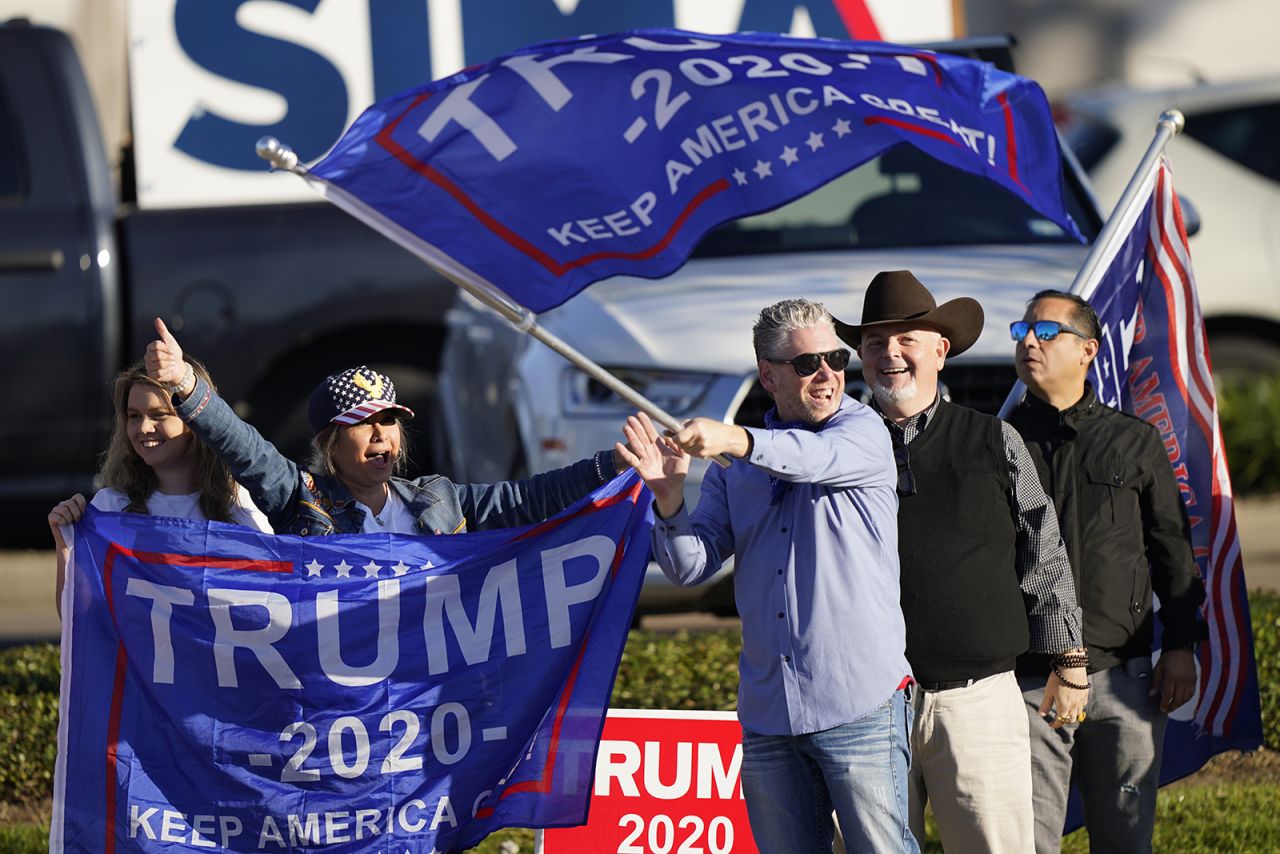 Supporters of President Trump cheer as passing cars honk their horns near a polling location on Election Day, in Houston. 
