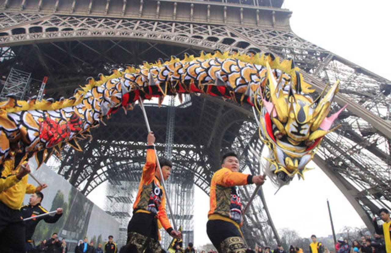 People dance with costumes to mark the Chinese New Year at the Eiffel Tower in Paris on Saturday. 