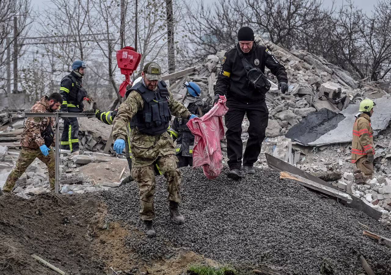 Police officers carry fragments of a body found under debris of a residential house destroyed by a Russian missile strike in the town of Vilniansk, Zaporizhzhia region, Ukraine, on November 17.