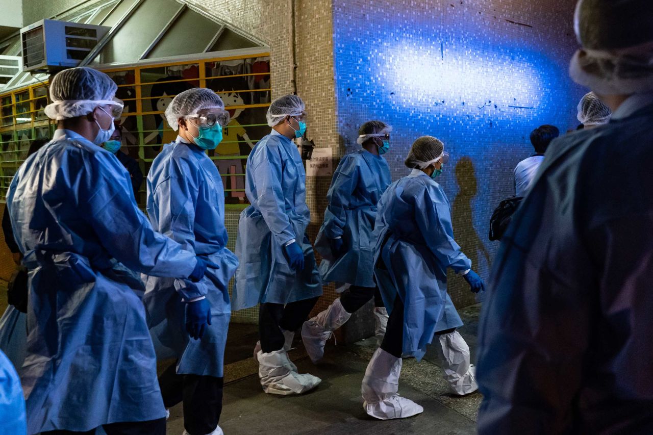 Officials arrive at a public housing building as residents are evacuated from their home to a quarantine center, after multiple infections of the novel coronavirus were detected at a housing estate in Hong Kong on March 14.