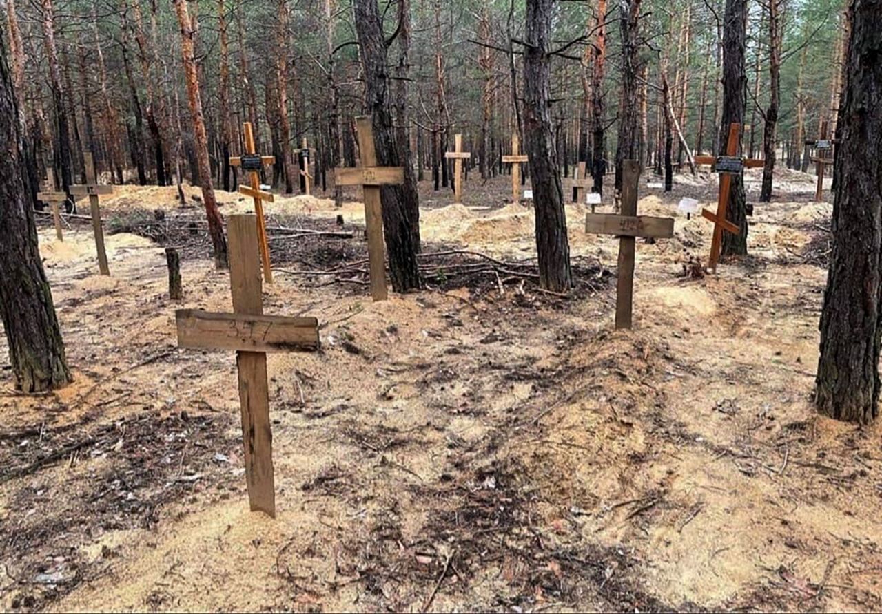 Crosses mark the location of several bodies at a mass burial site in Izyum, Ukraine. 