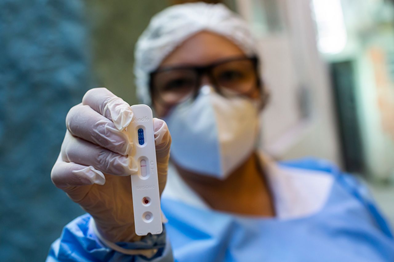 A wealth worker holds a positive COVID-19 rapid test at Favela da Mangueira on September 3, in Rio de Janeiro, Brazil.