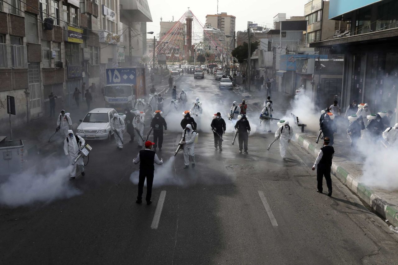 Firefighters disinfect a street against the coronavirus in Tehran, Iran, on March 13.