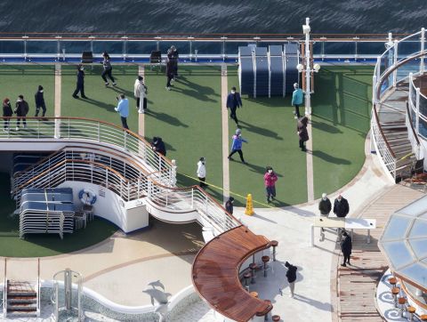 Masked passengers are seen on the deck of the cruise ship Diamond Princess docked at Yokohama Port, near Tokyo, Friday, February 7.