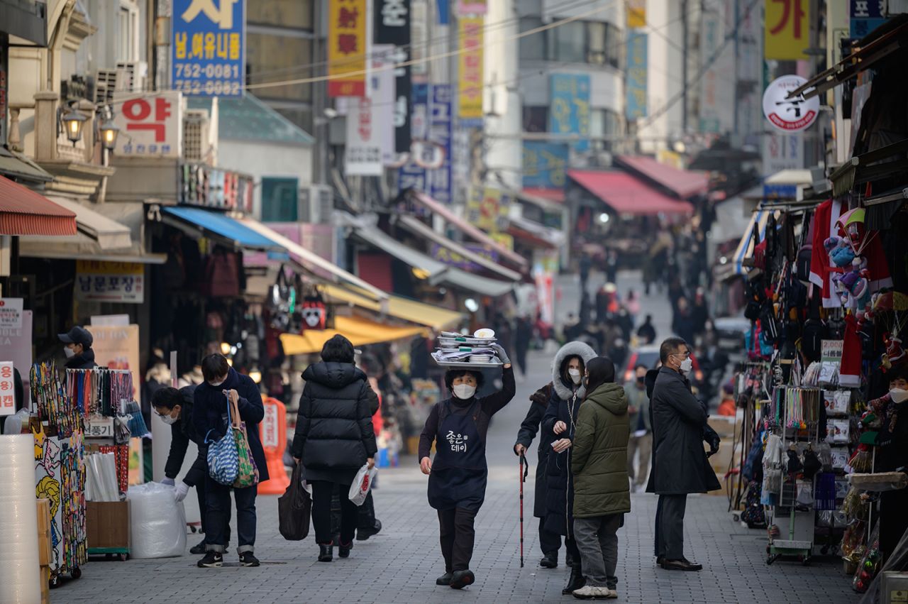 A restaurant worker carries a tray of food through Namdaemun market in Seoul, South Korea, on December 1.