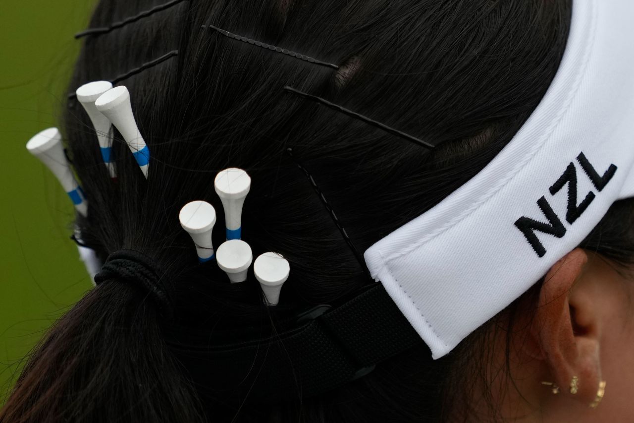 New Zealand's Lydia Ko carries spare tees in her hair during the third round of the women's golf tournament on August 9. Ko and Switzerland’s Morgane Métraux were atop the leaderboard before the fourth and final round. 