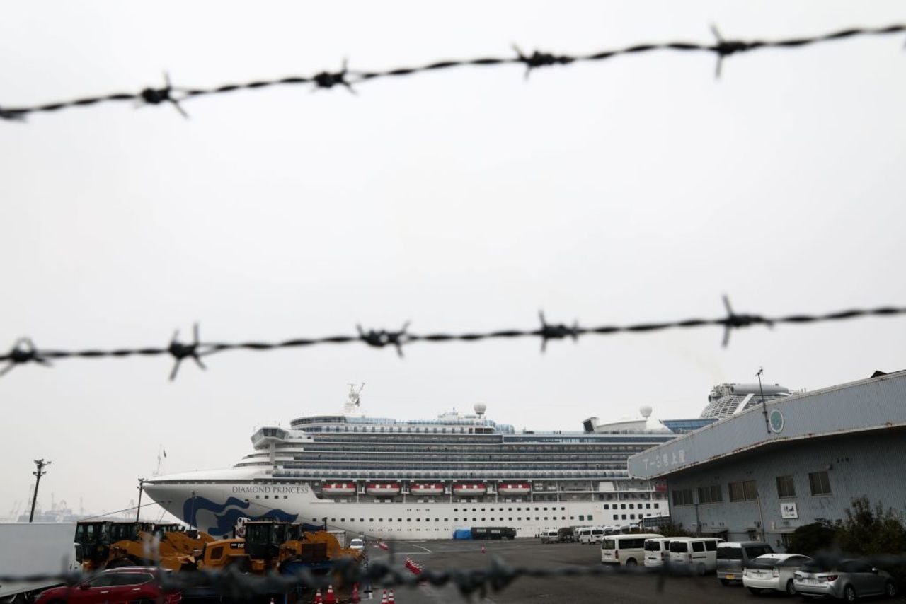 The Diamond Princess cruise ship, which has thousands of quarantined onboard due to fears of the new COVID-19 coronavirus, is seen through a fence at the Daikoku Pier Cruise Terminal in Yokohama port on February 16, 2020.?