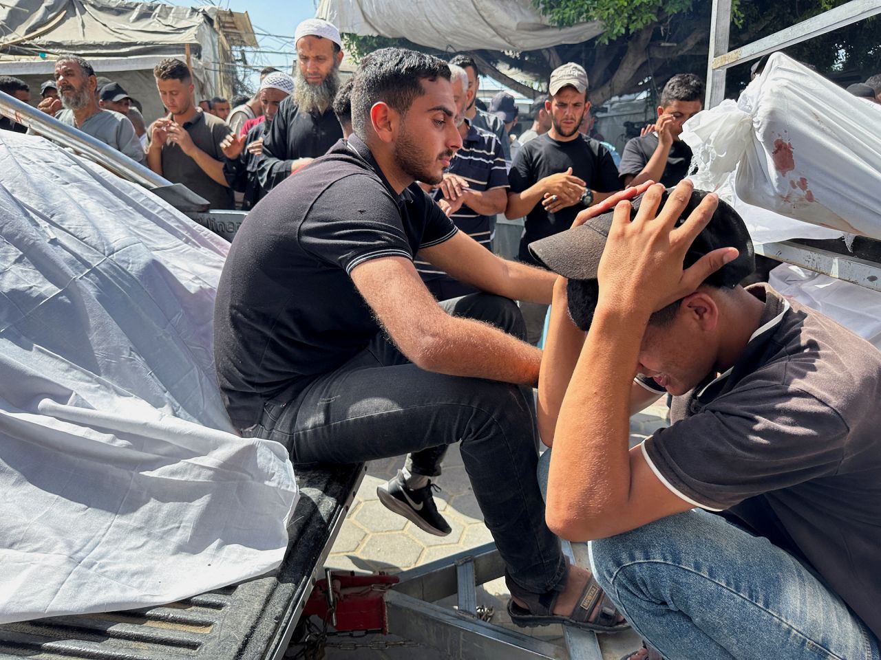אבלים מגיבים במהלך הלווייתם של פלסטינים שנהרגו בתקיפות ישראליות בדיר אל-בלח, עזה, ב-8 ביוני.