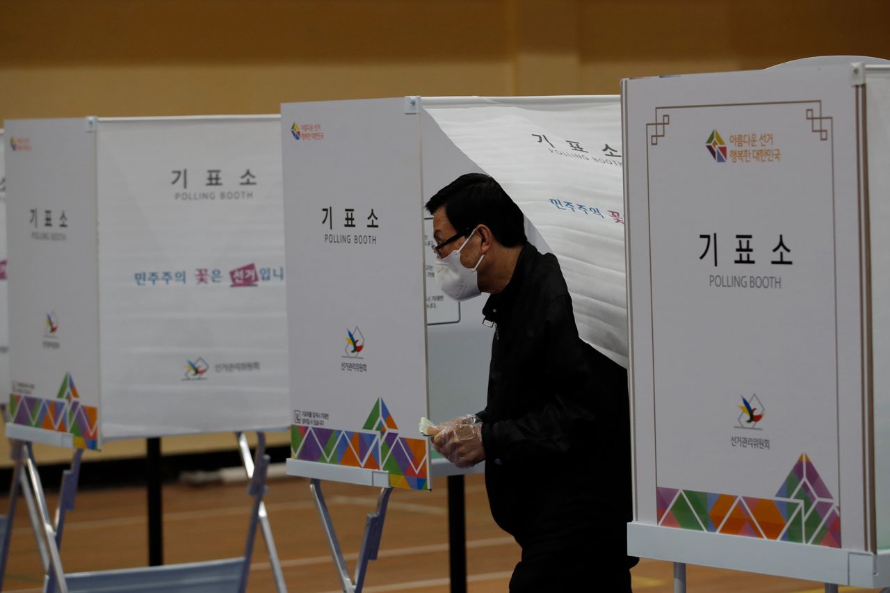 A voter wearing a face mask to help protect against the spread of the coronavirus exits out to cast his vote for the parliamentary election at a polling station in Seoul, South Korea, on Wednesday, April 15. 