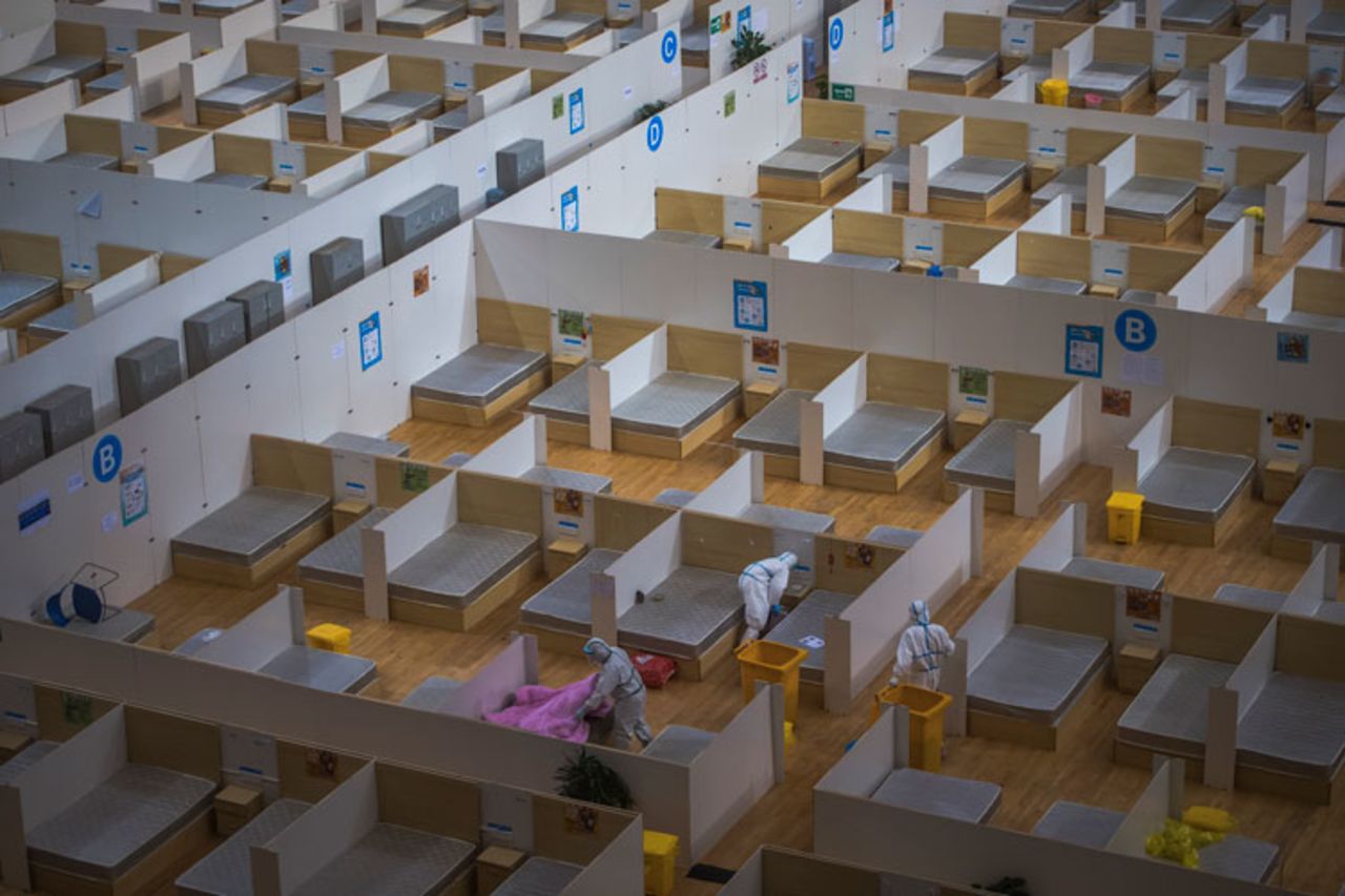 Workers in protective suits clean up a makeshift hospital converted from a sports venue after it officially closed in Wuhan on March 8.