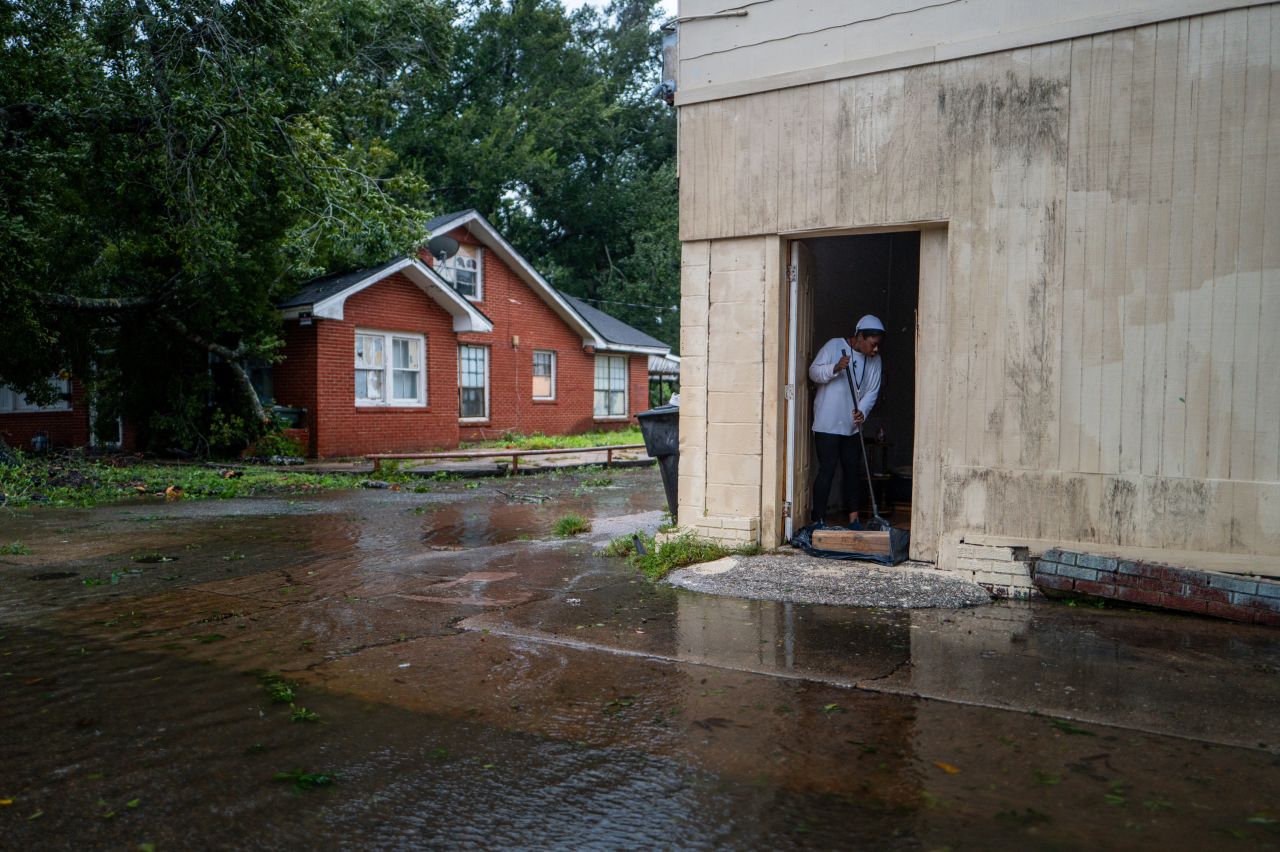 Lekenya McKay sweeps floodwater out of her home in Houma, Louisiana, on September 11.