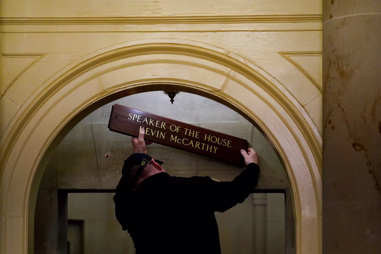 A worker replaces a sign over McCarthy's office on Saturday. 