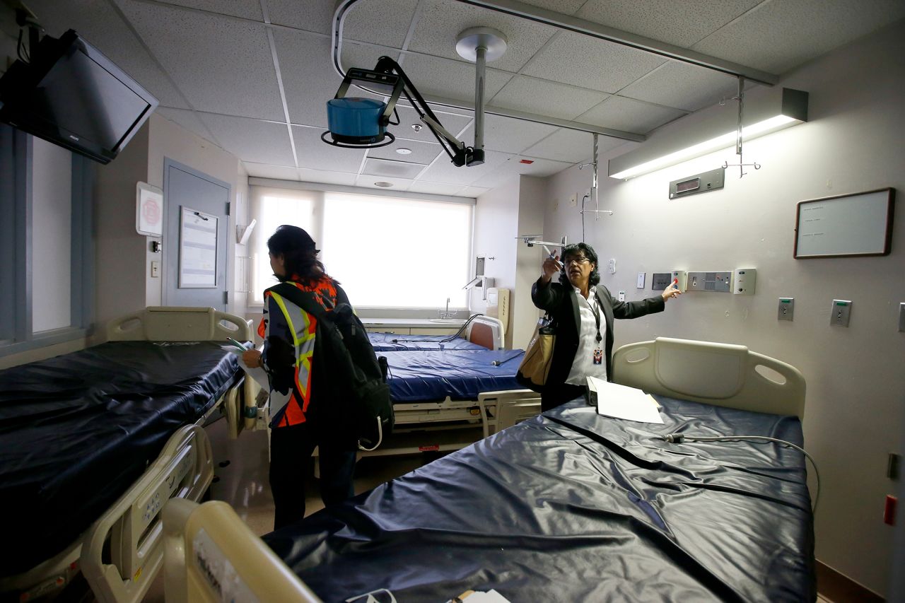 Susie McCann, right, of the Arizona health department, assess a room in the emergency area with a member of the U.S. Army Corps of Engineers as they tour the currently closed St. Luke's Medical Center hospital to see the viability of reopening the facility for possible future use due to the coronavirus Wednesday, March 25, in Phoenix.