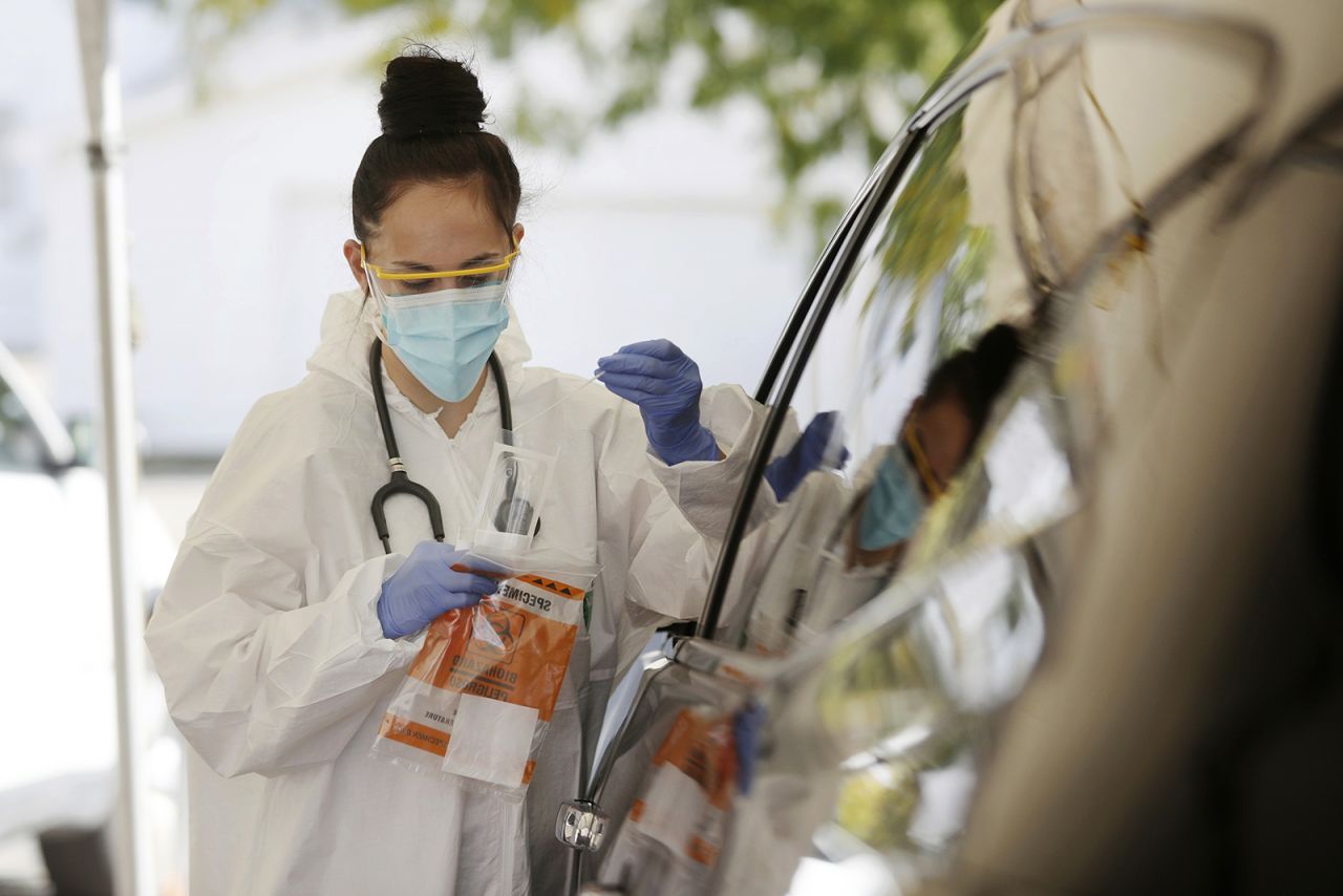 Medical Assistant Savannah Dela Vega places a nasal swab in a container for coronavirus testing at the drive-thru clinic in Casper, Wyoming, on Friday, October 9, 2020.