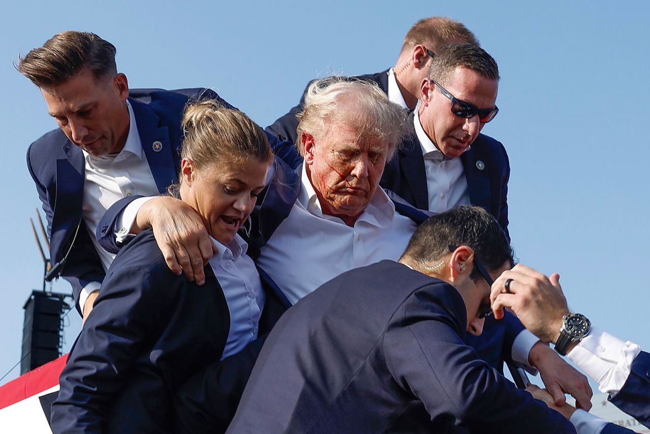 Republican presidential candidate former President Donald Trump is rushed offstage by US Secret Service agents after being grazed by a bullet during a rally on July 13, in Butler, Pennsylvania.