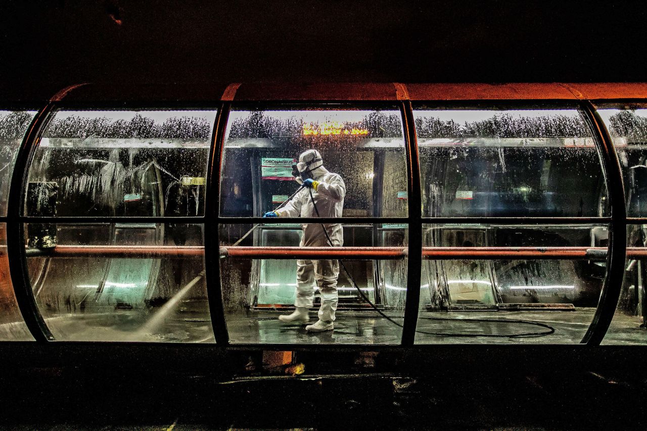A volunteer worker disinfects a public bus station in Curitiba, Brazil on April 1.