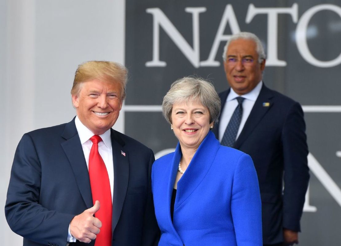 US President Donald Trump (L) gestures as he poses alongside Britain's Prime Minister Theresa May (R) as Portugal's Prime Minister Antonio Costa (TOP) looks on during the opening ceremony of the NATO in Brussels on July 11, 2018