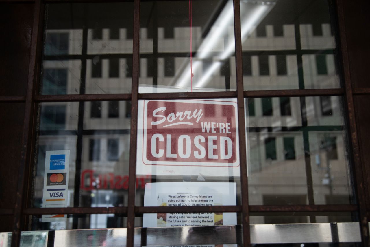 A "closed" sign hangs on the door of a restaurant in Detroit in April.