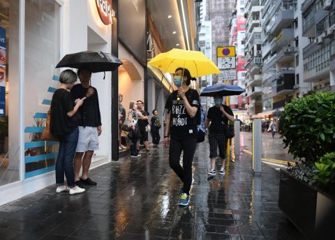 Protesters duck for cover from the rain in Hong Kong.