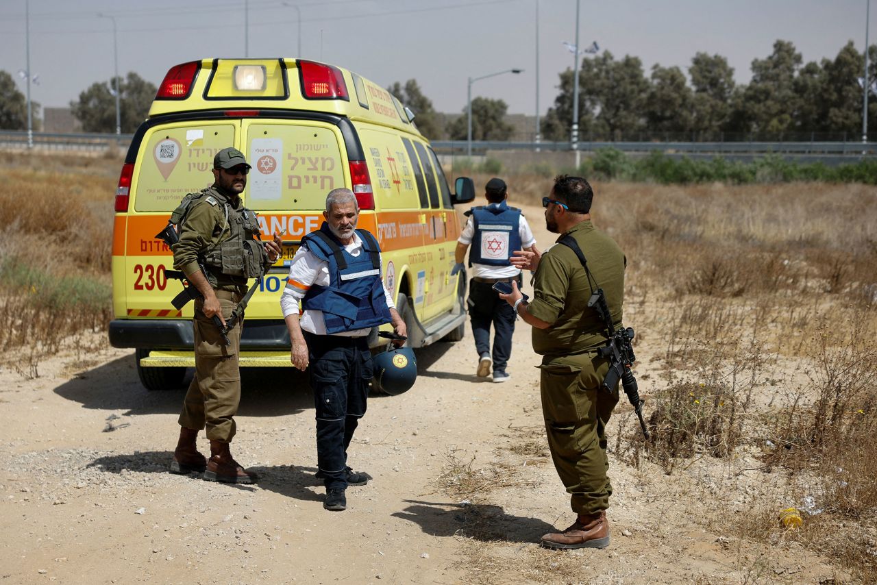 Israeli soldiers and medics walk near an ambulance after a rocket attack on the Kerem Shalom crossing on May 5.
