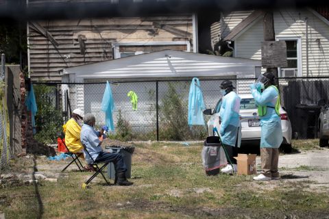 Workers talk residents through a Covid-19 self-administered test on June 23 at a mobile testing site set up on a vacant lot in Chicago's Austin neighborhood.