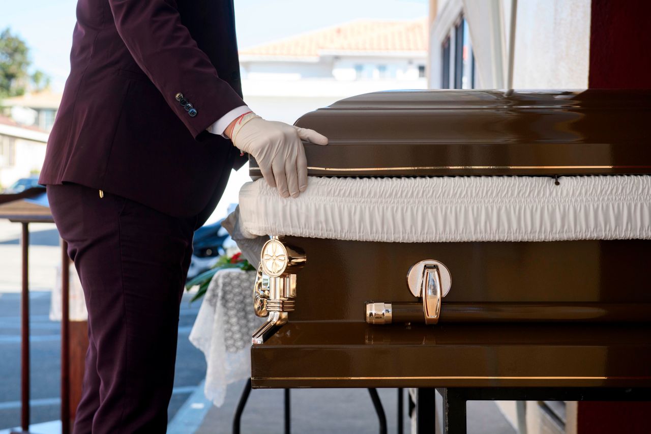 Funeral director Steven Correa moves the casket of someone said to have died from Covid-19 in preparation for burial at Continental Funeral Home in East Los Angeles, California, on December 31.