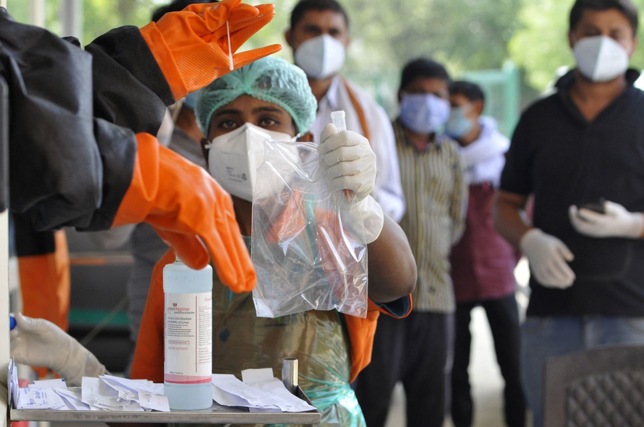 A medic handles a sample collected for Covid-19 testing at a booth outside Sharda Hospital in Greater Noida, India. 