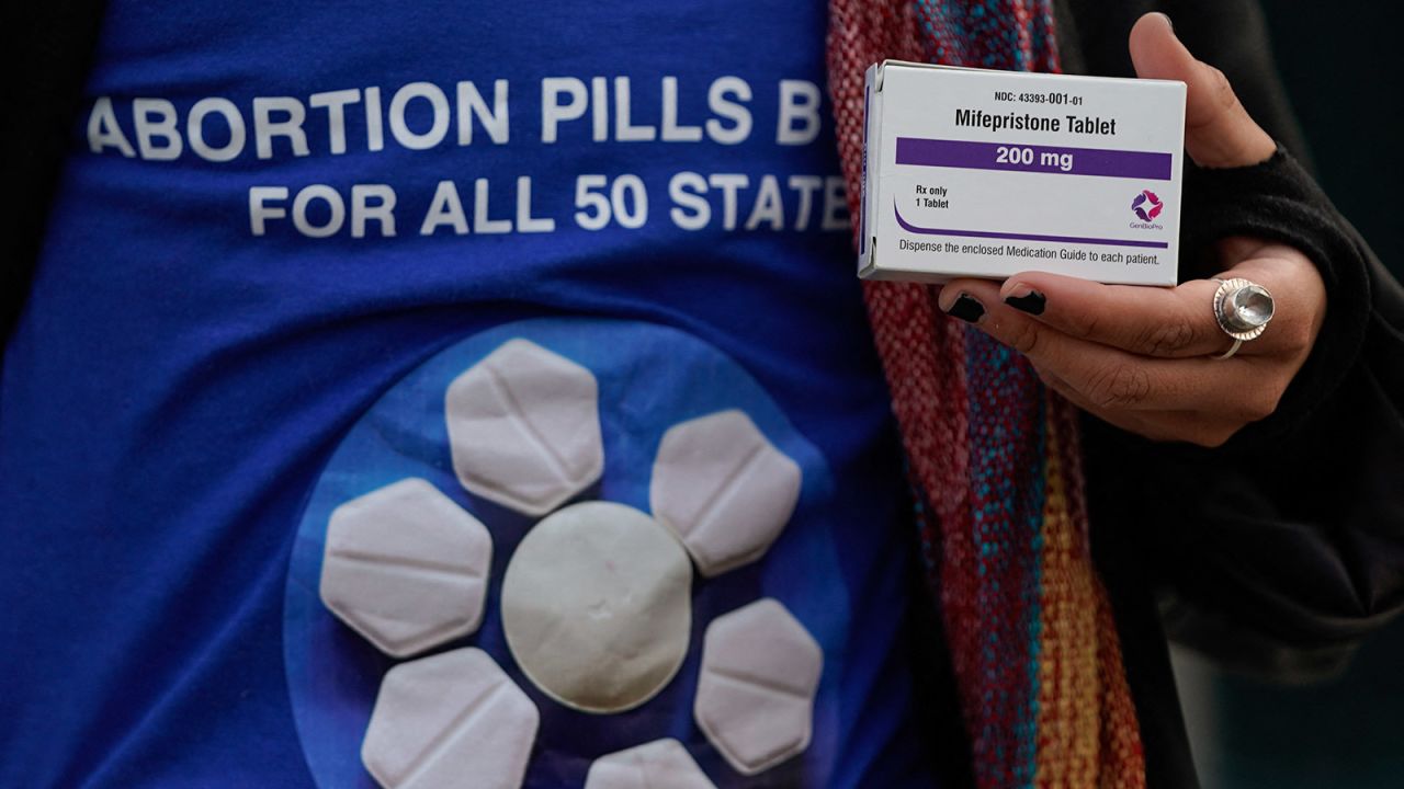 A pro-abortion rights activist holds a box of mifepristone during a rally in front of the U.S. Supreme Court on March 26.