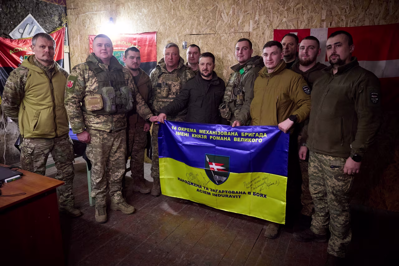 Ukraine's President Volodymyr Zelensky, center, poses for a picture with Ukrainian servicemen as he visits their position in a front line near Kupiansk, Kharkiv region, in Ukraine on February 19.