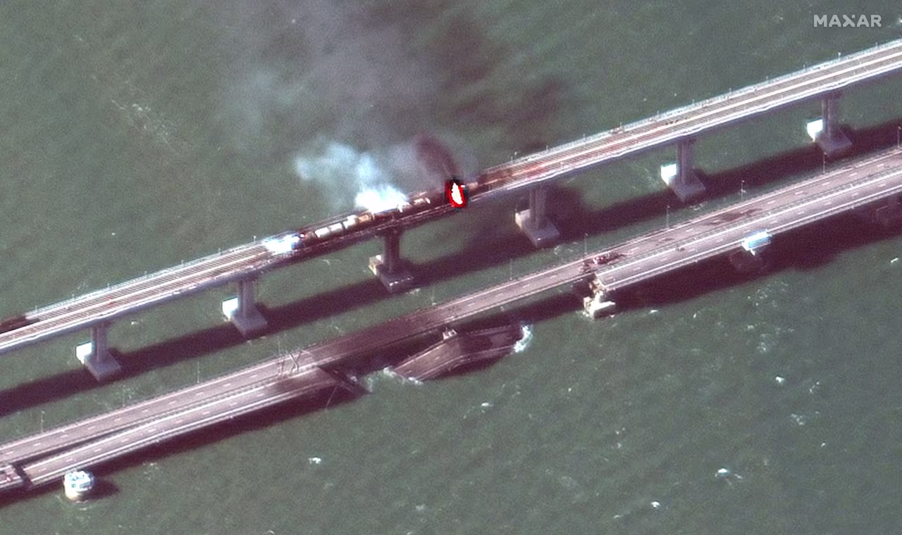 A close up view of damaged bridge and rail cars on fire Crimea bridge.
