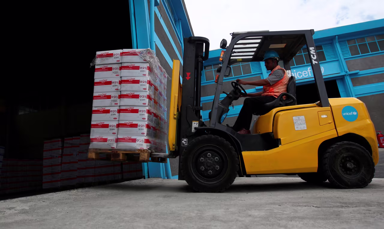 In this file photo from April 22, 2016, a worker transports boxes of therapeutic food to be distributed to the malnourished population inside the UNICEF warehouse in Addis Ababa, Ethiopia.