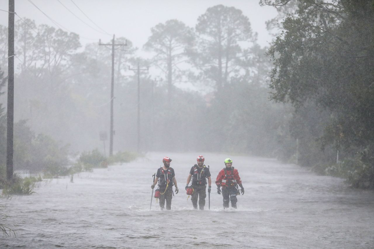 Rescue workers with Tidewater Disaster Response wade through a tidal surge while looking for people in need of help in Steinhatchee, Florida.