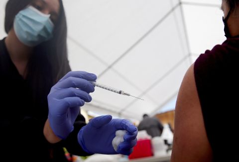 A health care worker administers a dose of the Pfizer COVID-19 vaccine at CIELO, an Indigenous rights organization, on April 10 in Los Angeles.