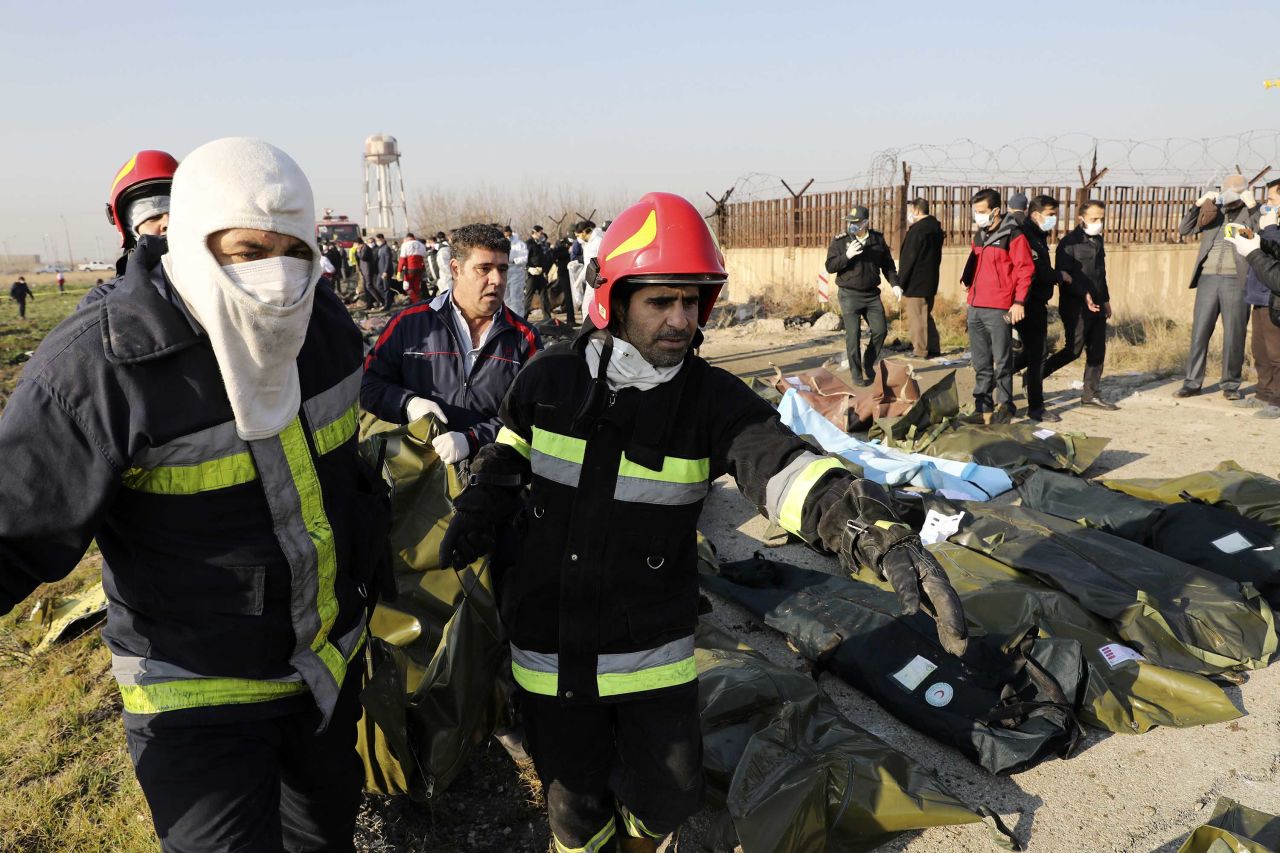 Rescue workers carry victims' remains at the crash site.