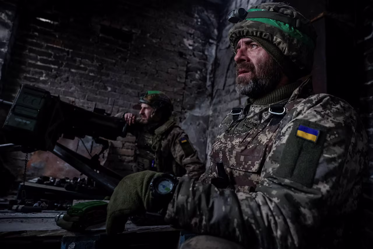 Ukrainian servicemen are seen near an automatic grenade launcher at their positions in Bakhmut, Ukraine, on February 25. 